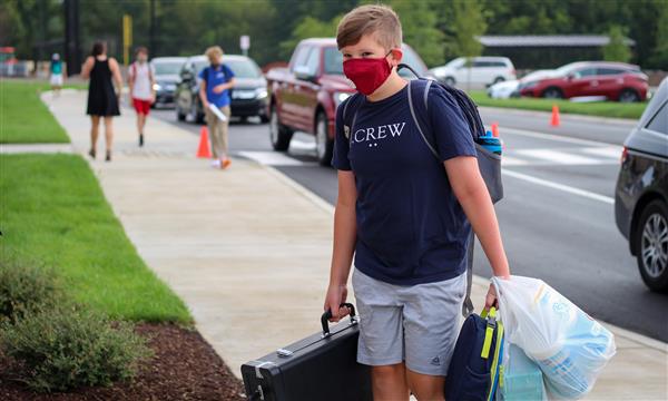 student carries bags into school